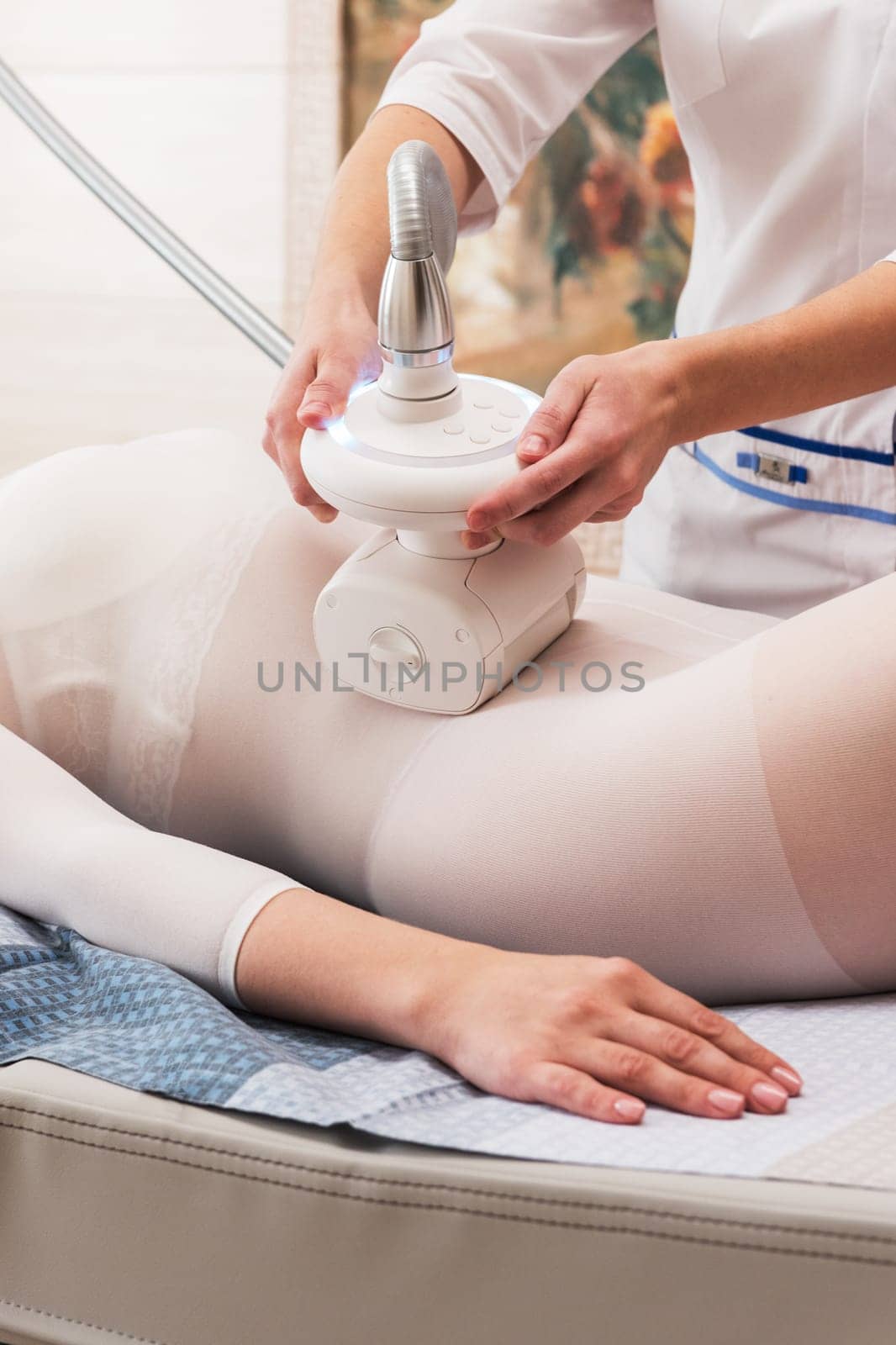 Woman in special white suit getting anti cellulite massage in a spa salon. LPG, and body contouring treatment in clinic. Lipomassage procedure on female body.
