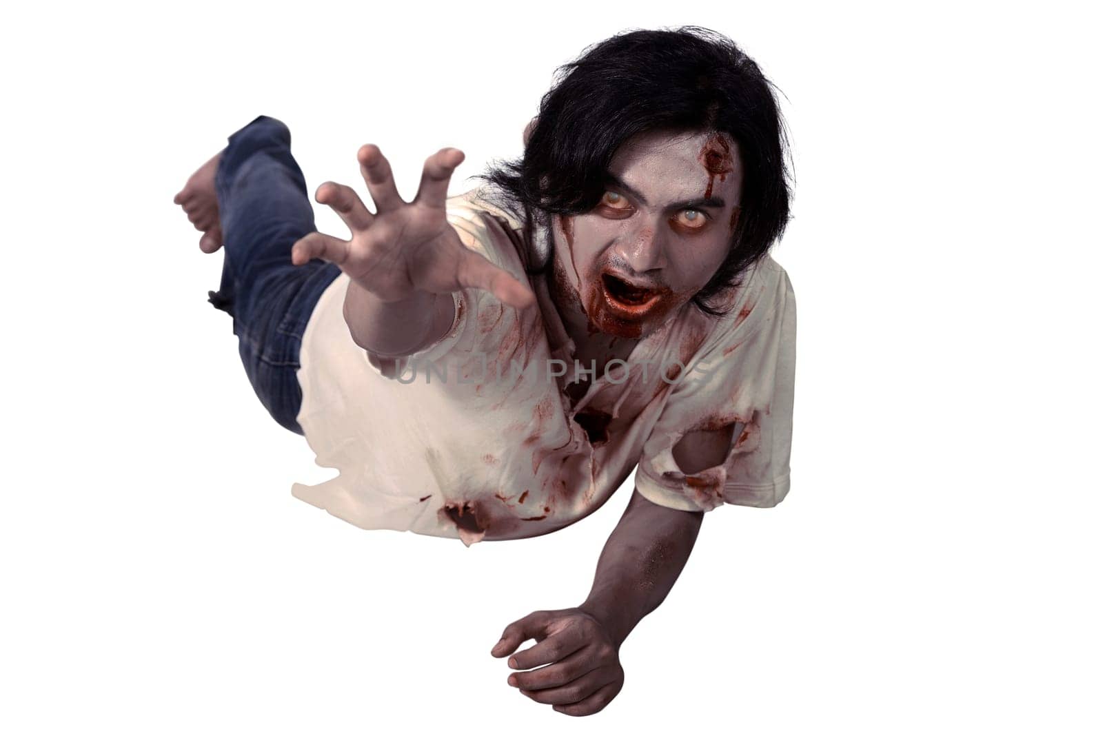 Male zombie crouching on the floor isolated over white background