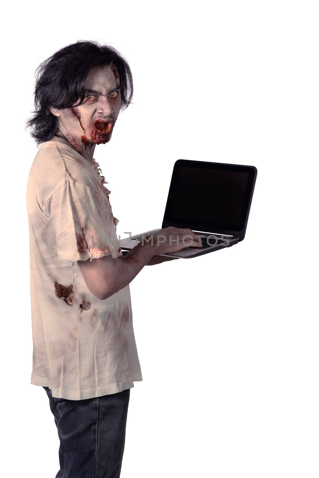 Creepy asian male zombie typing with laptop isolated over white background