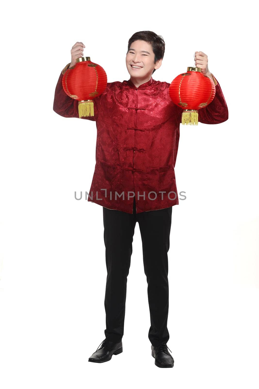 Young chinese man in cheongsam suit holding lantern isolated over white background