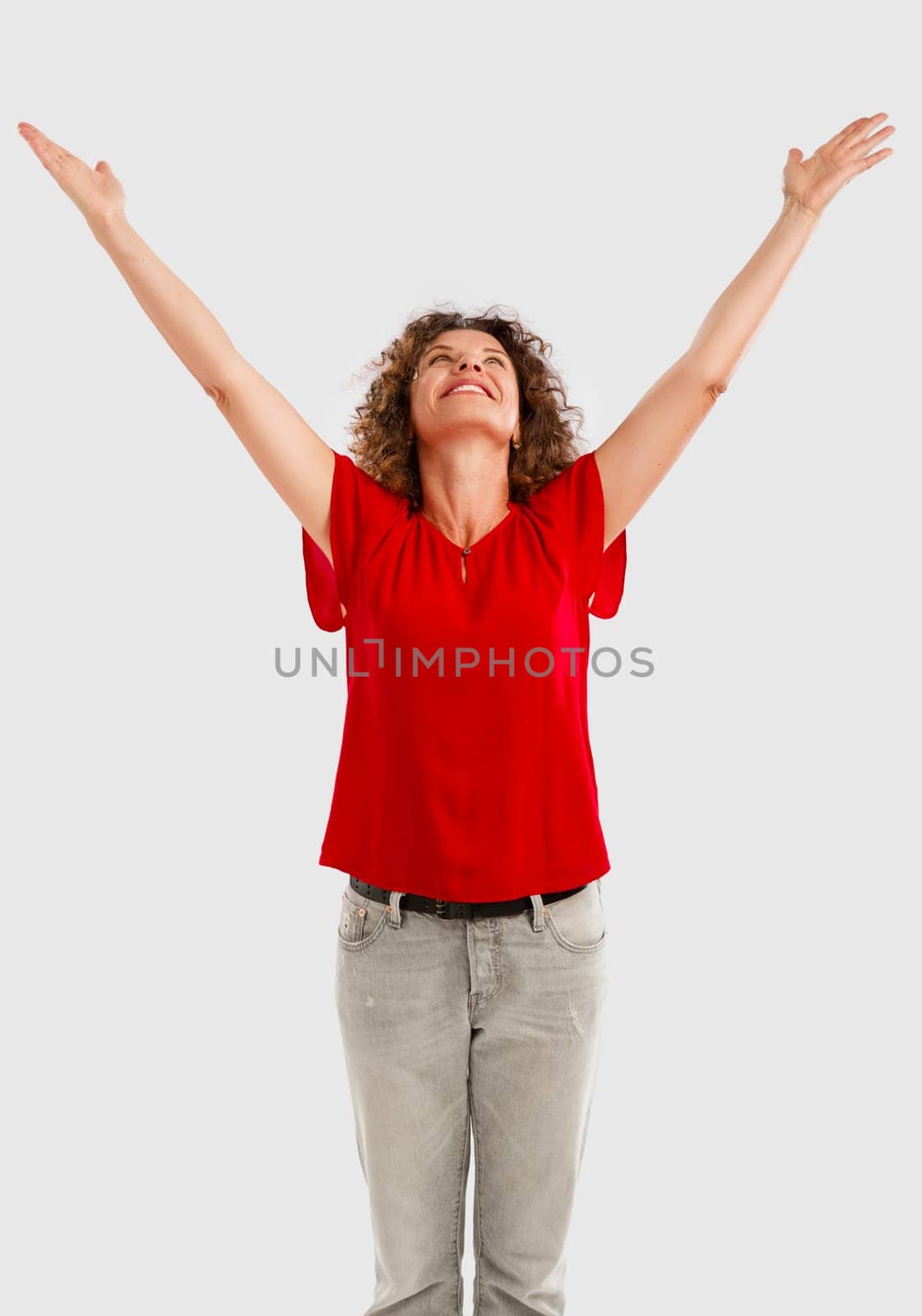 Portrait of a happy middle aged brunette with arms up