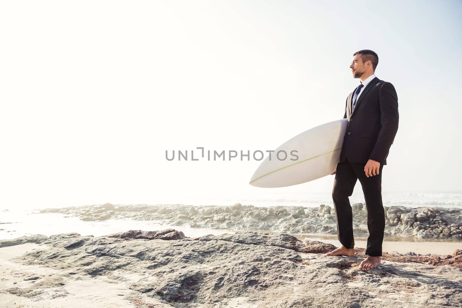 A Businessman holding is surfboard after a long day of work