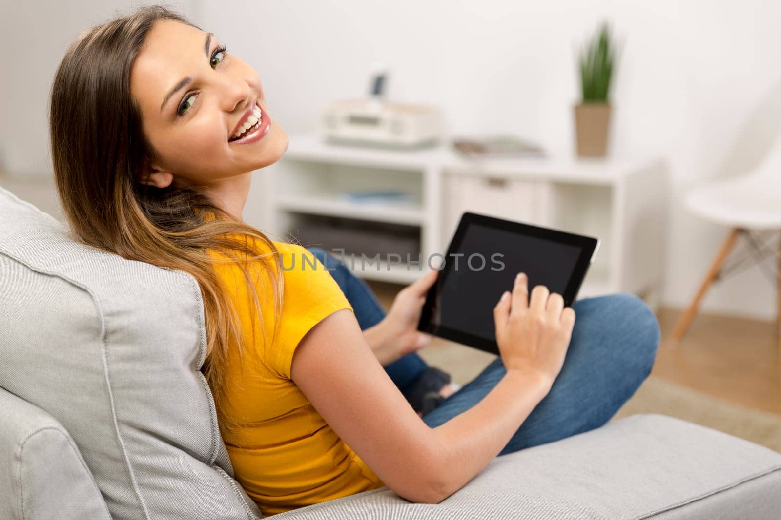 Beautiful woman at home working with a tablet