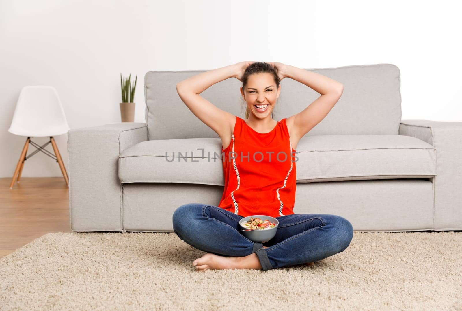 Beautiful happy woman at home eating a strawberries