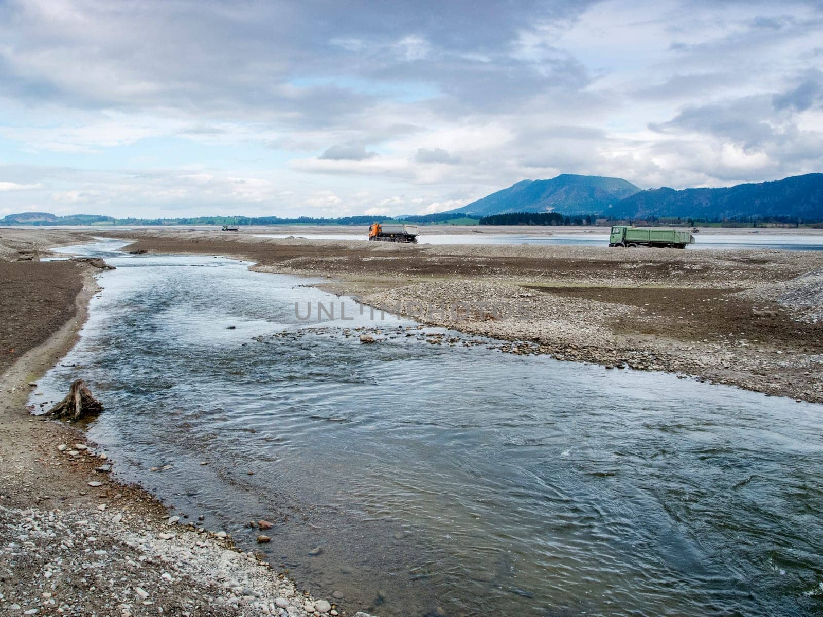 Course of the river Lech in the drained Forggensee near Füssen / Bavaria. The Forggensee is fed by thawing snow from the high Alps and is a reservoir for sedimentary rocks. In spring,the lake is emptied to remove the sedimentary rock. In summer,the lake has returned to its normal water level and is navigated by excursion boats.