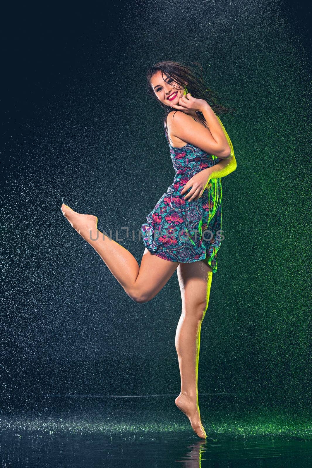 Young beautiful woman with splash of rain. Studio shot