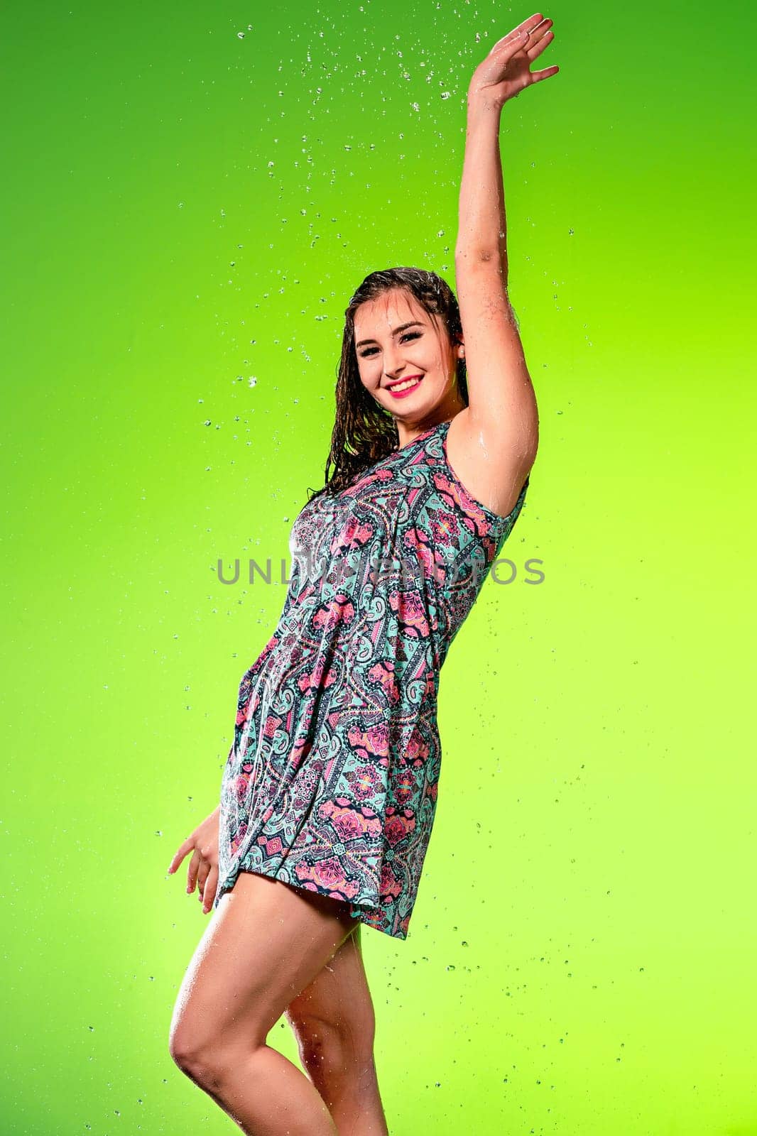 Young beautiful woman with splash of rain. Studio shot