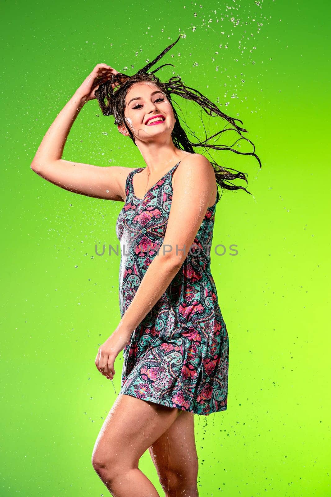 Young beautiful woman with splash of rain. Studio shot