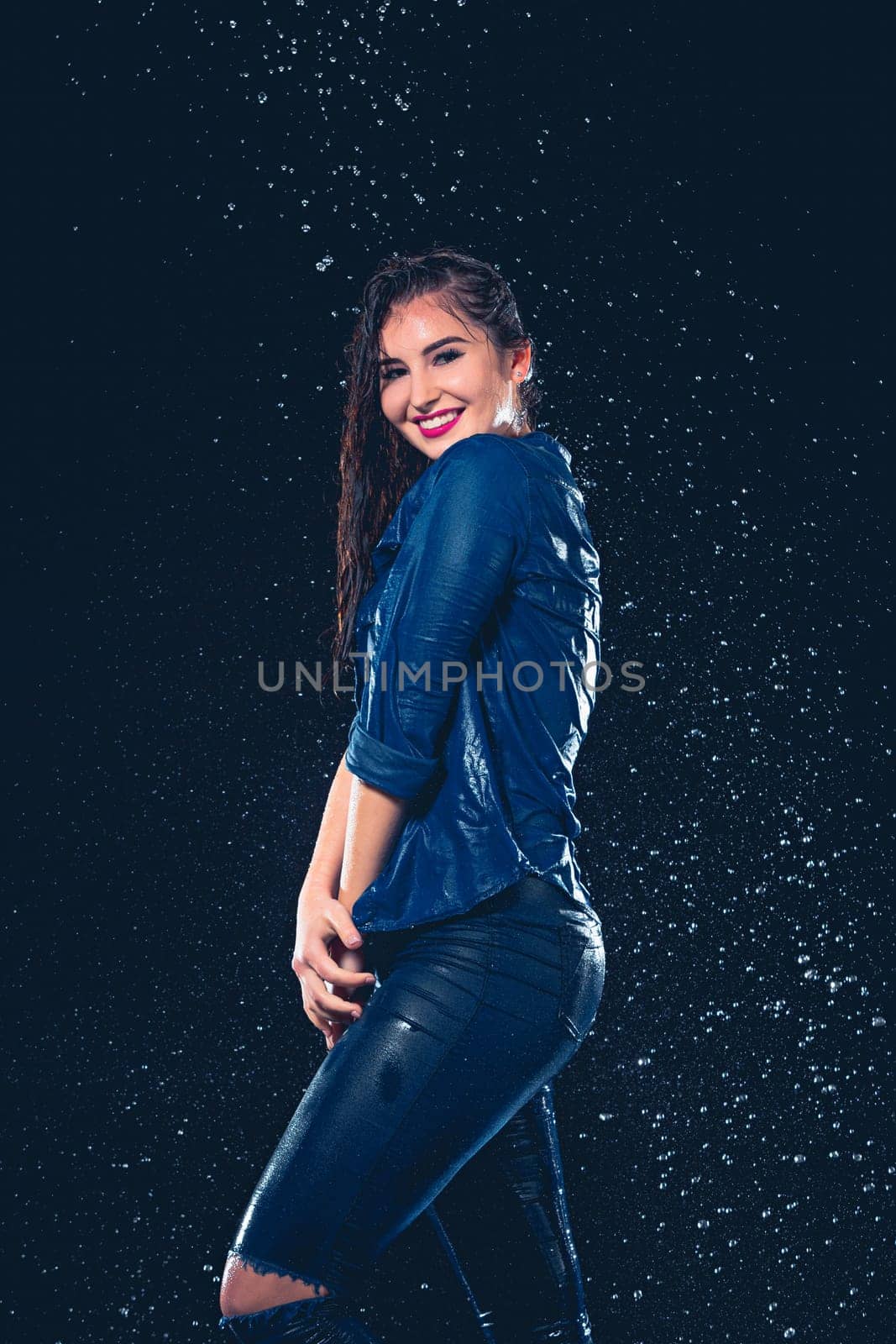 Young beautiful woman with splash of rain. Studio shot