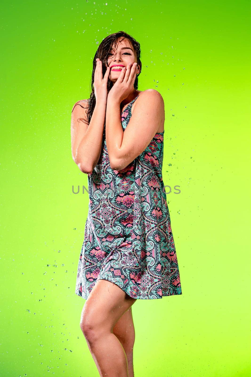Young beautiful woman with splash of rain. Studio shot
