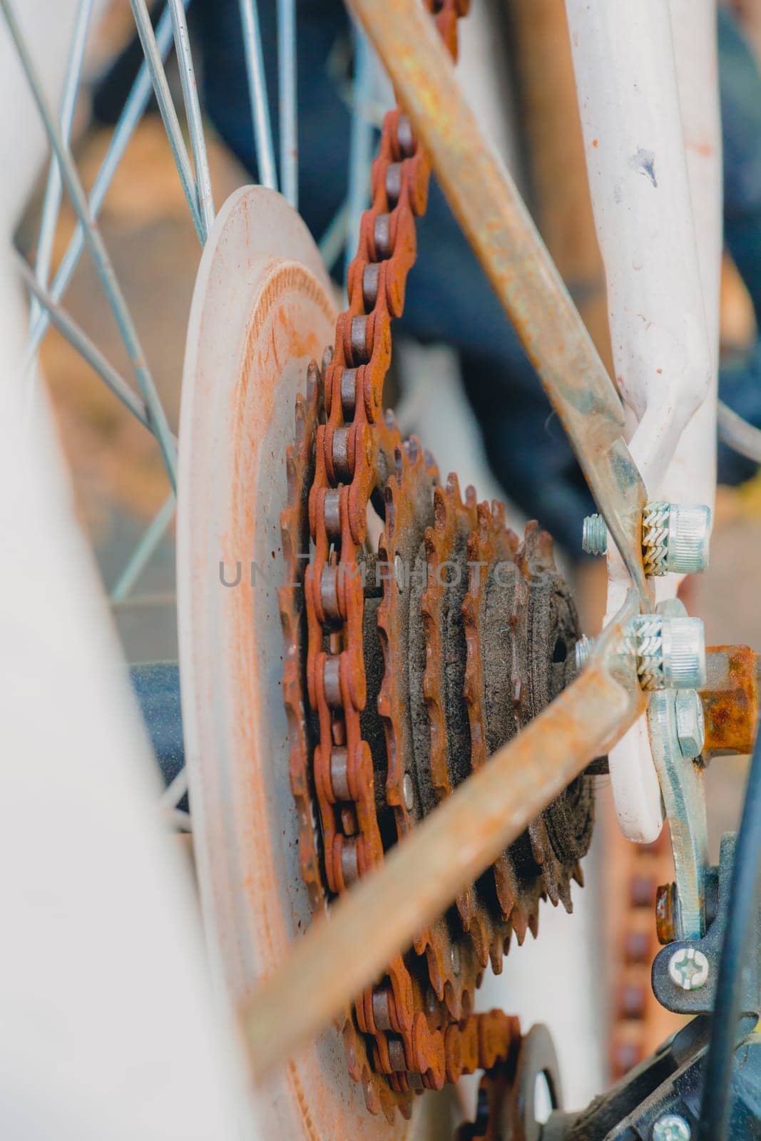 Old rusty chain on white bicycle. Selective focus close up.