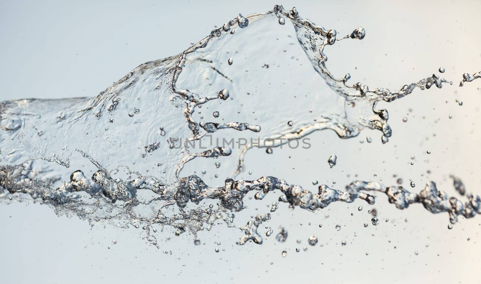 Splashes of water in the air against a bright background