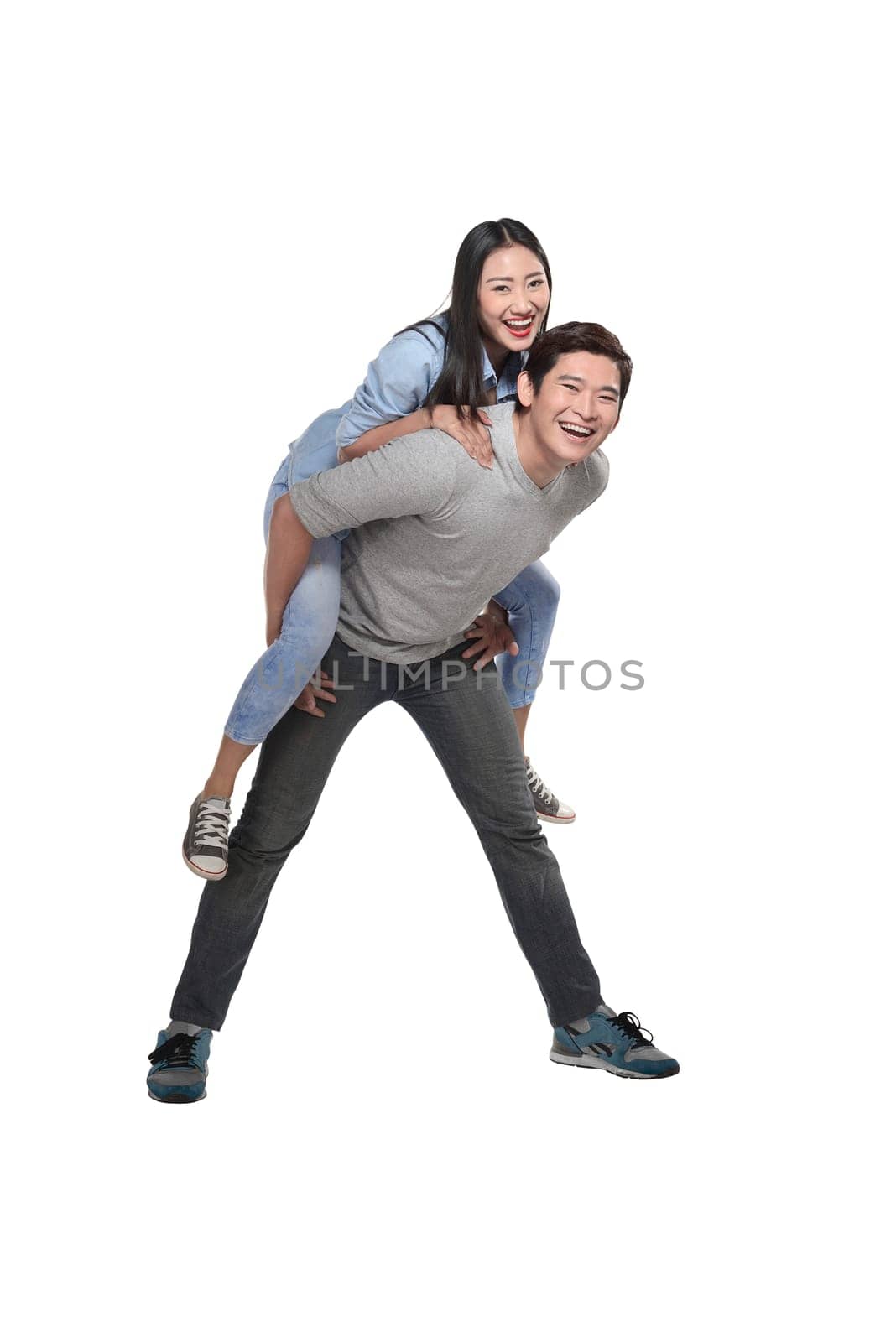 Young man carrying his laughing partner isolated over white background