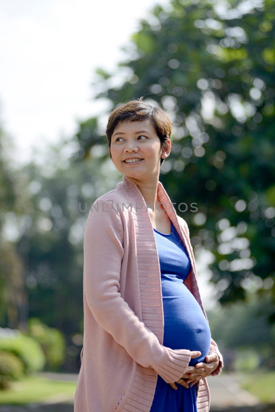 Pregnant mother posing on the outdoor when summer