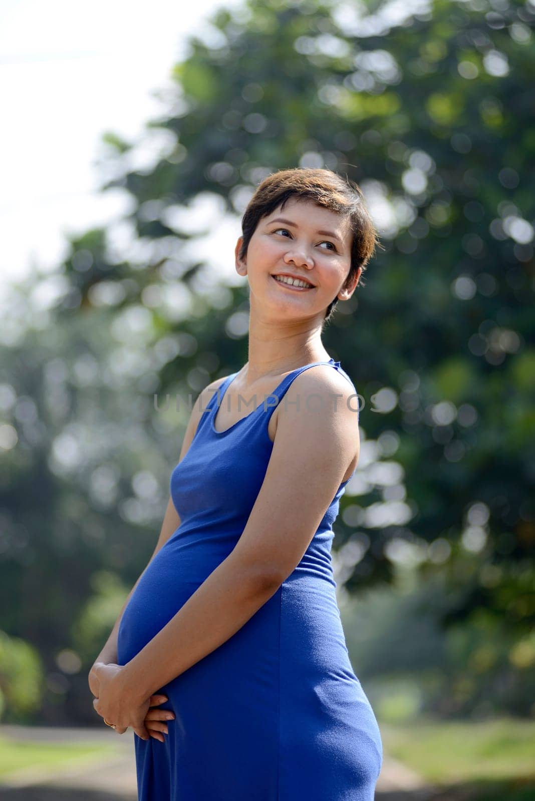 Pregnant mother posing on the outdoor when summer