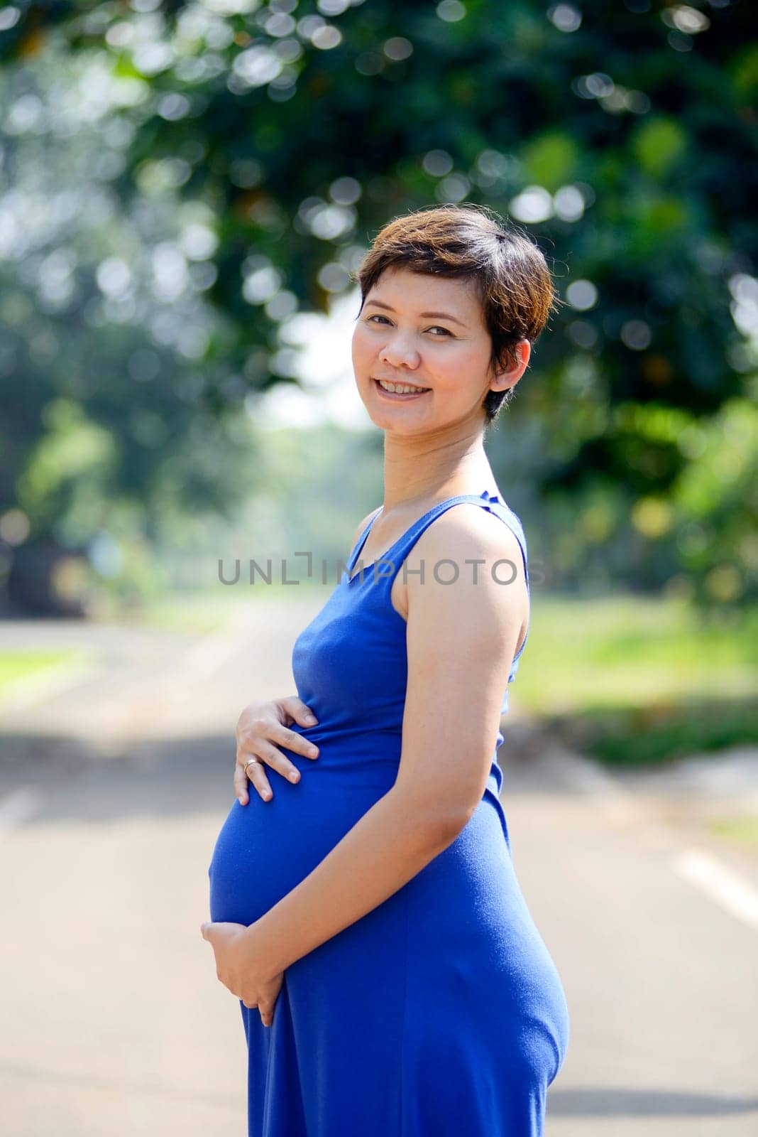 Pregnant mother posing on the outdoor when summer