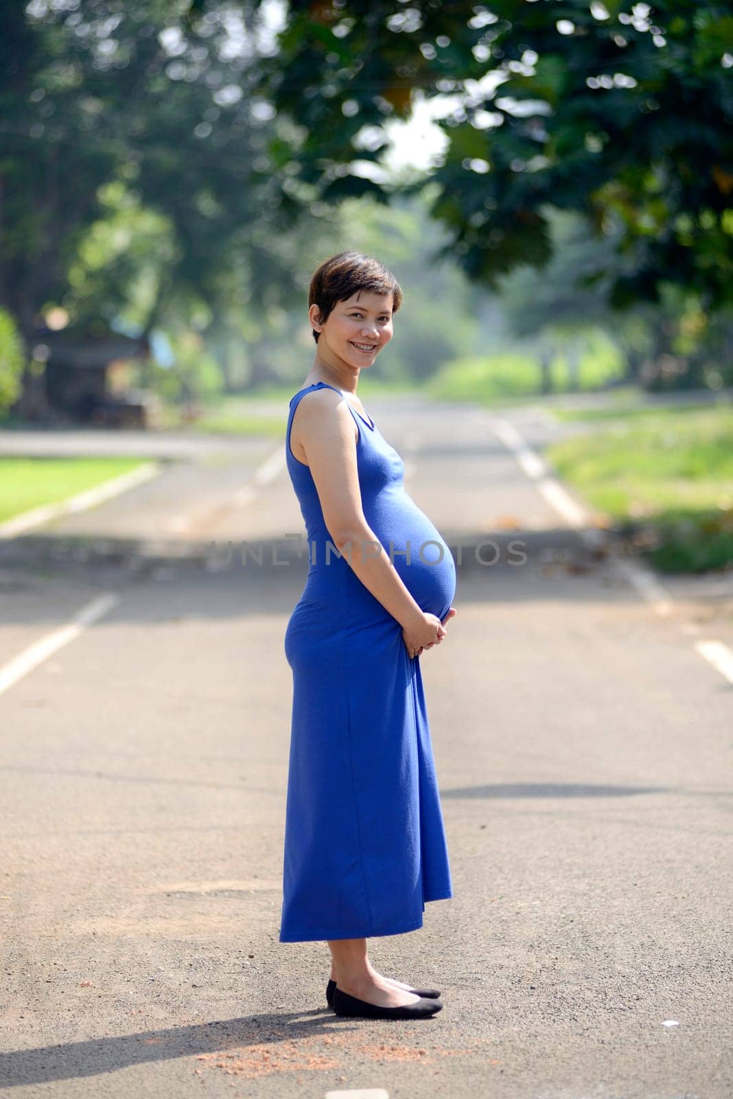 Pregnant mother posing on the outdoor when summer