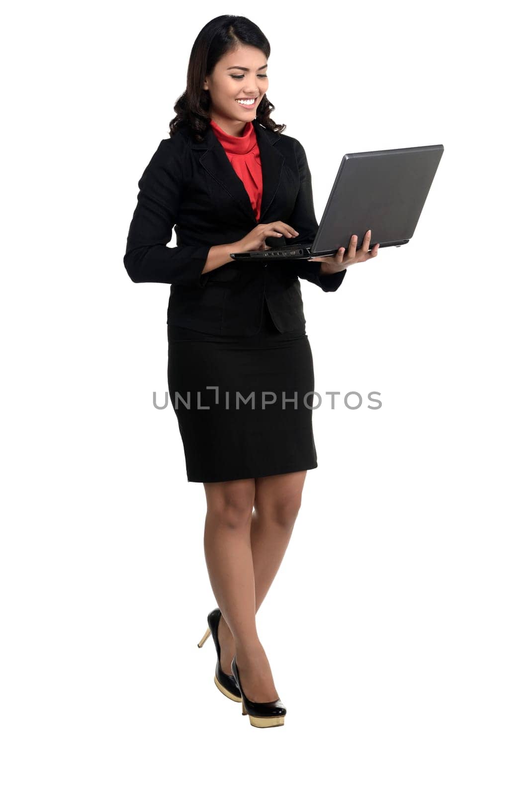 Asian business woman using laptop while standing isolated over white background