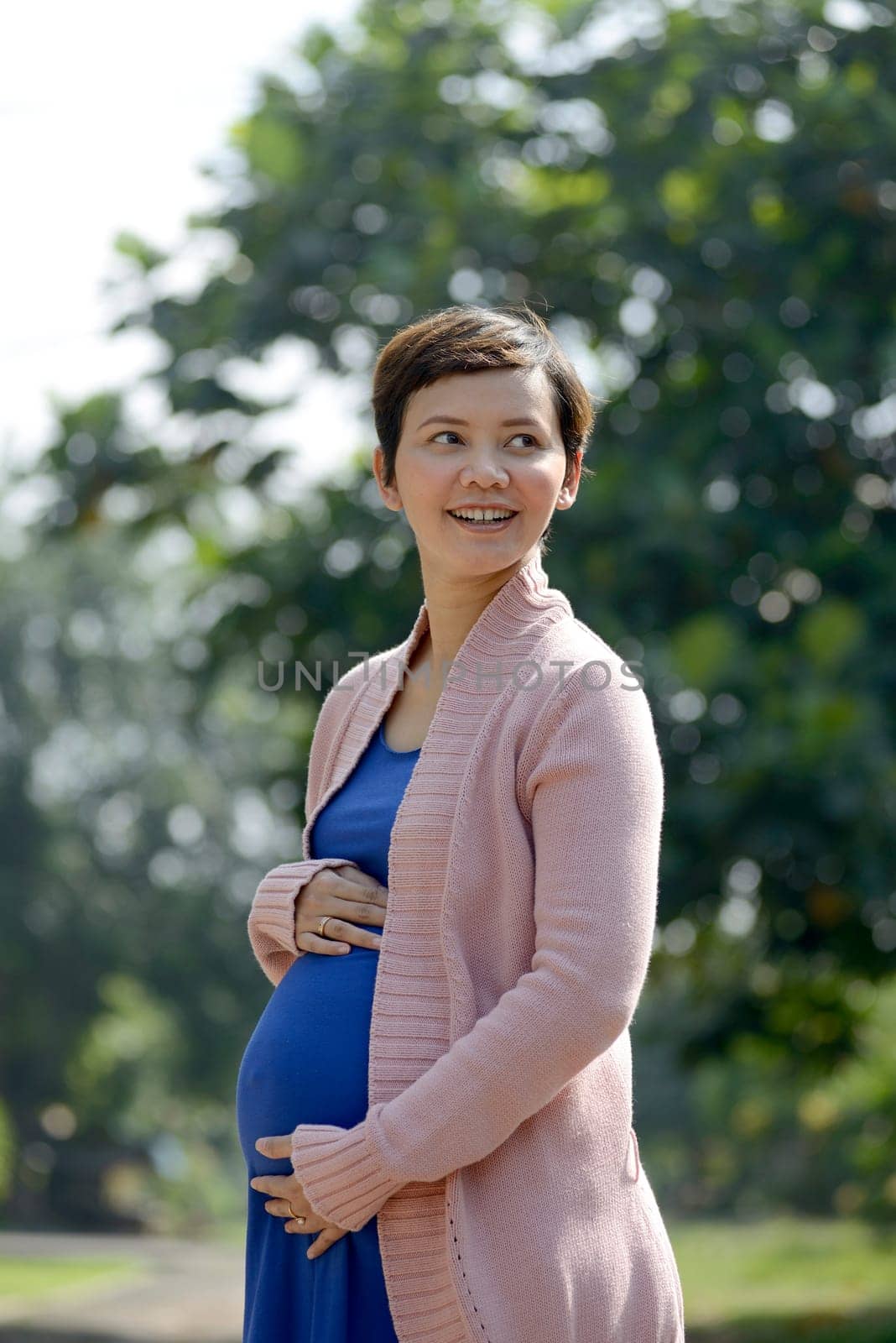Pregnant mother posing on the outdoor when summer
