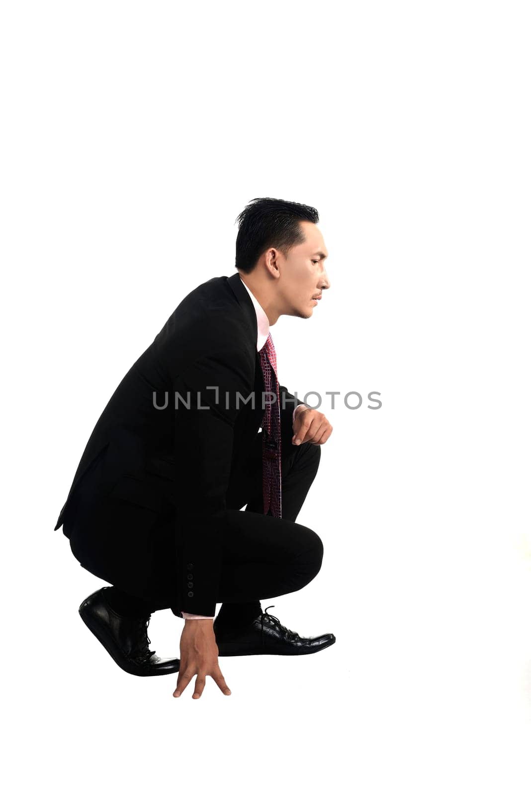 Asian business man squat isolated over white background