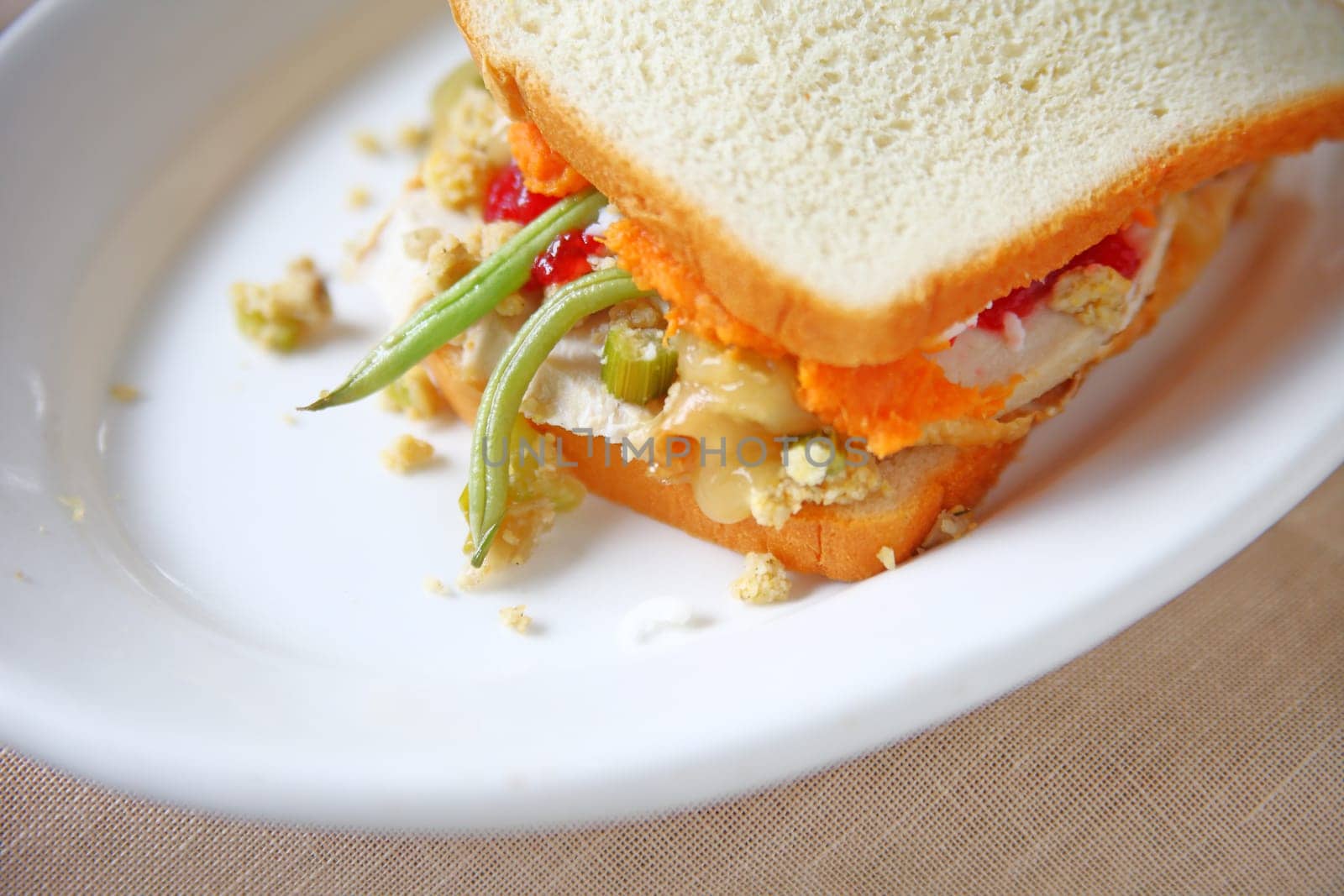 Closeup of turkey sandwich of Thanksgiving leftovers on white bread