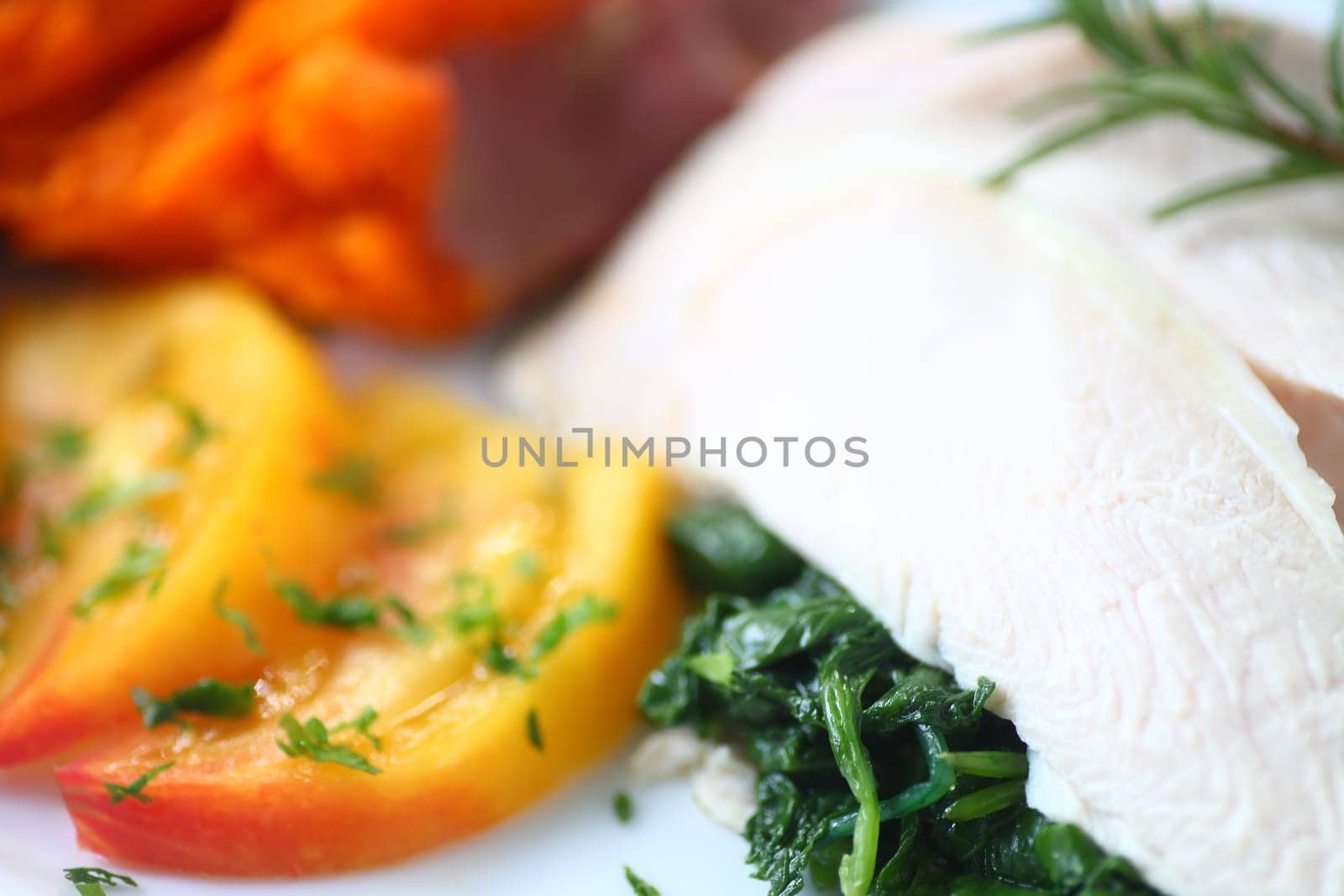 Poached chicken slices over sauteed baby kale with sweet potato and tomato