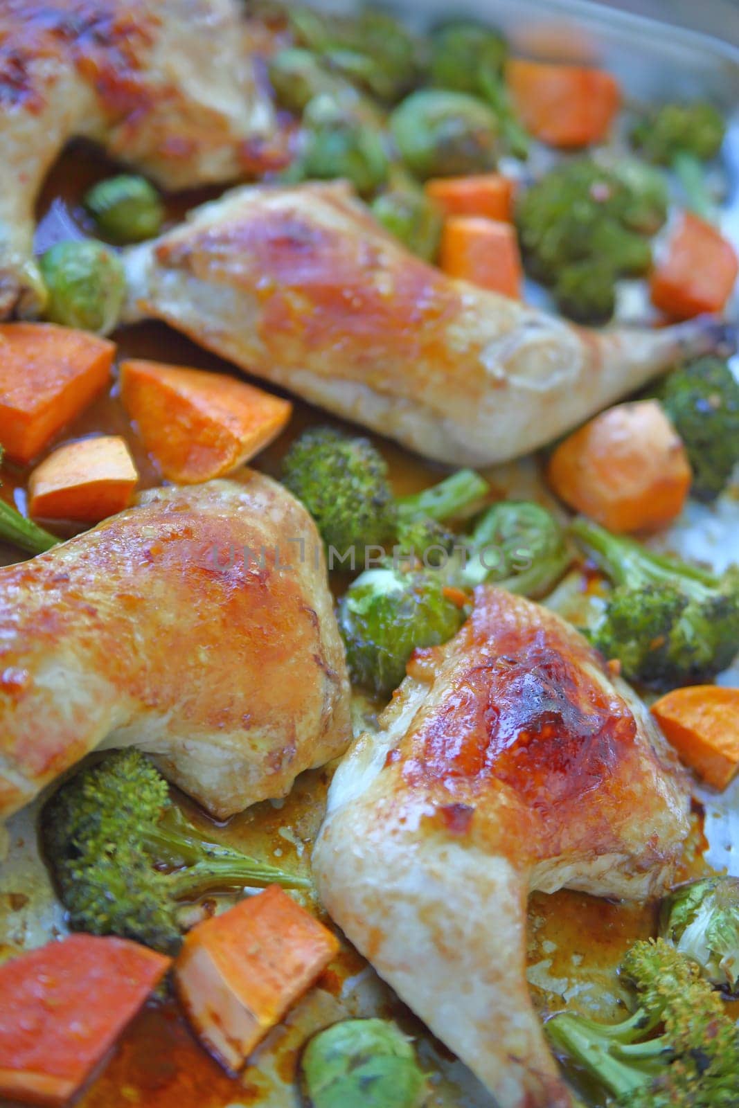 Chicken quarters roasting with broccoli, brussels sprouts and yam pieces