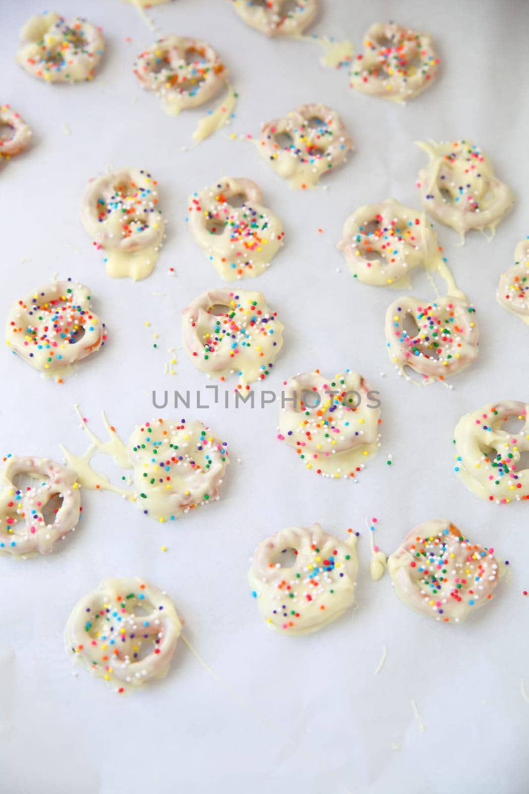 Homemade white chocolate-covered pretzels with colorful sprinkles and copy space
