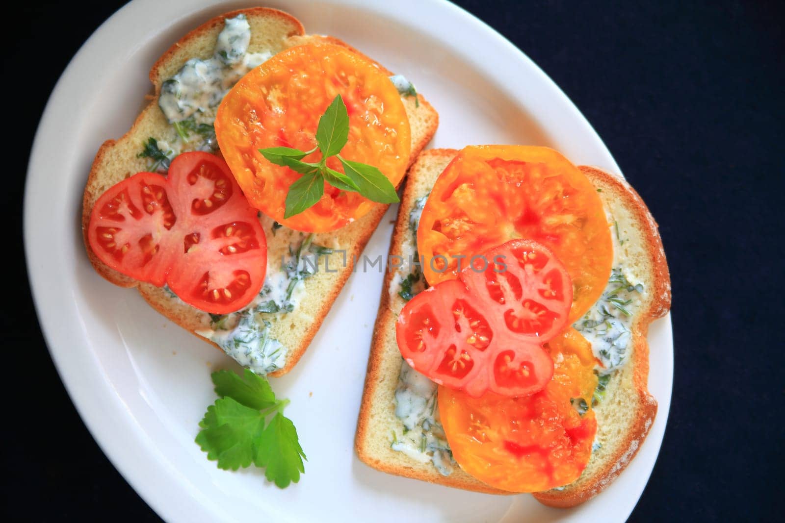 Tomato sandwich with heirloom tomatoes with cilantro mayonnaise on a white platter