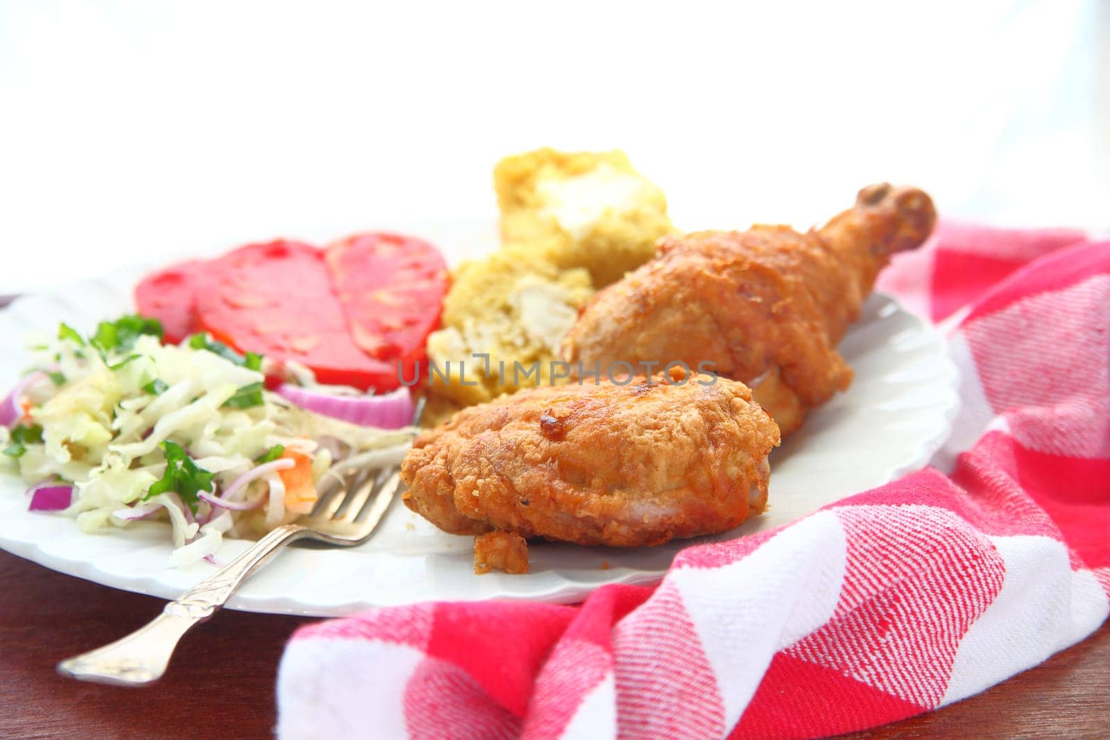 Platter of fried chicken, coleslaw, cornbread and tomatoes