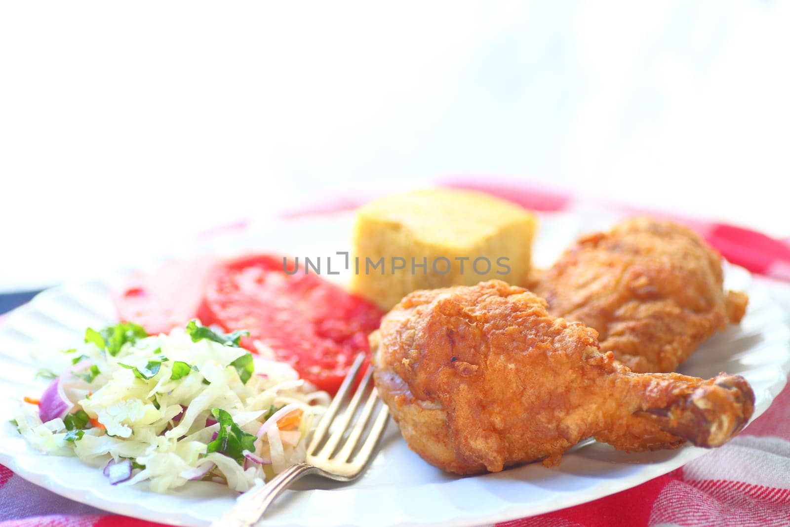 Fried chicken with coleslaw, tomatoes and cornbread with room for text