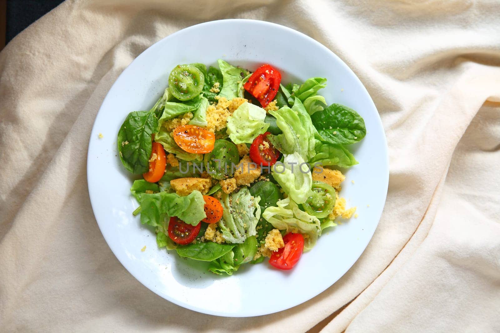Ovehead view of salad with cherry tomatoes and cornbread