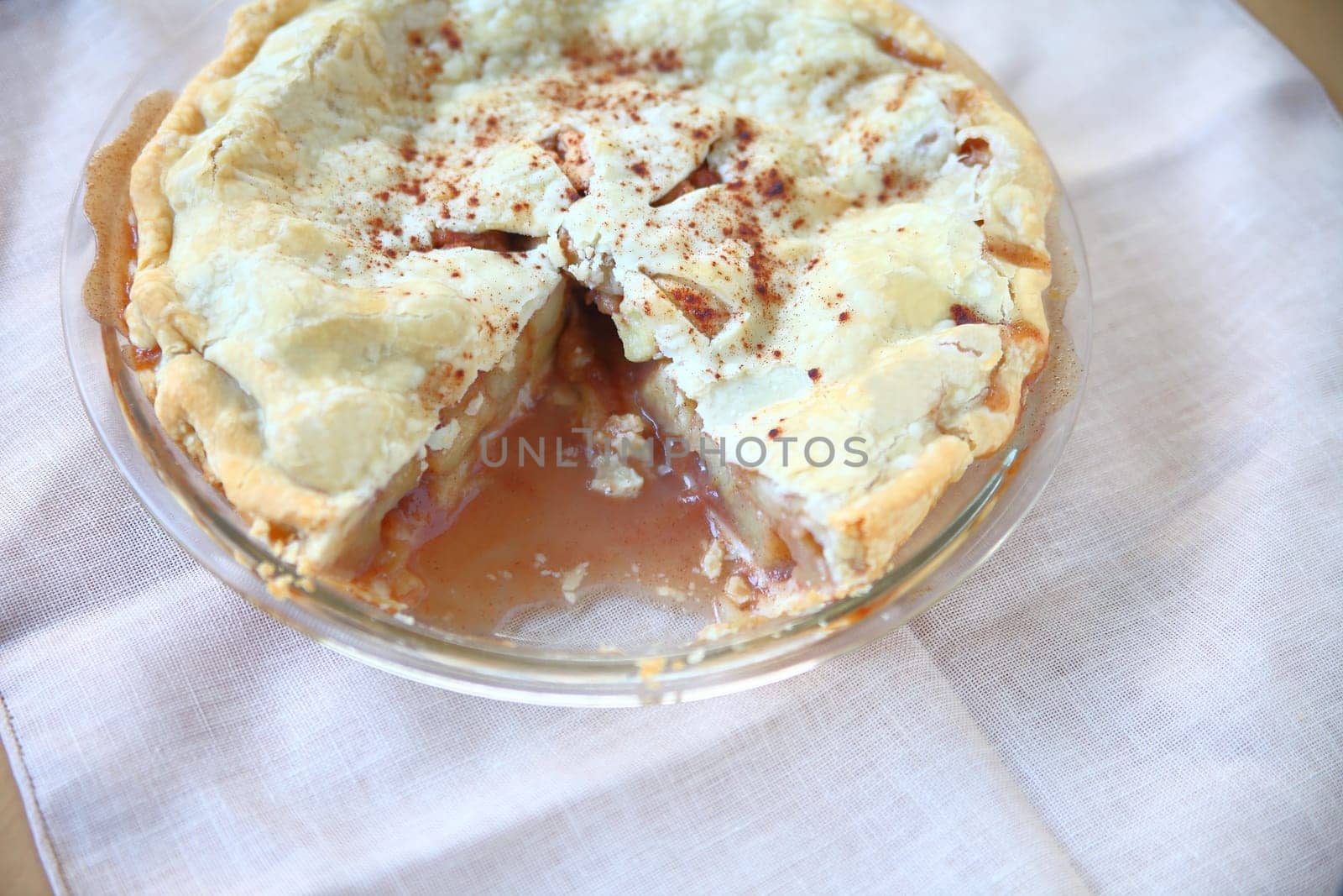 Overhead view of homemade apple pie sprinkled with cinnamon with copy space