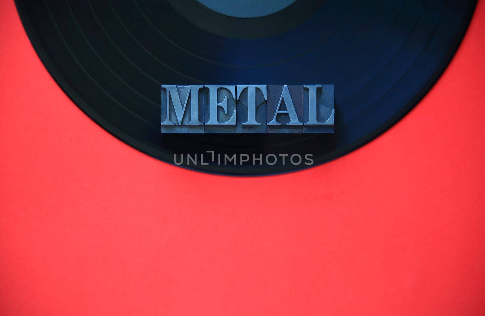Black vinyl record with the word metal on a red background with copy space