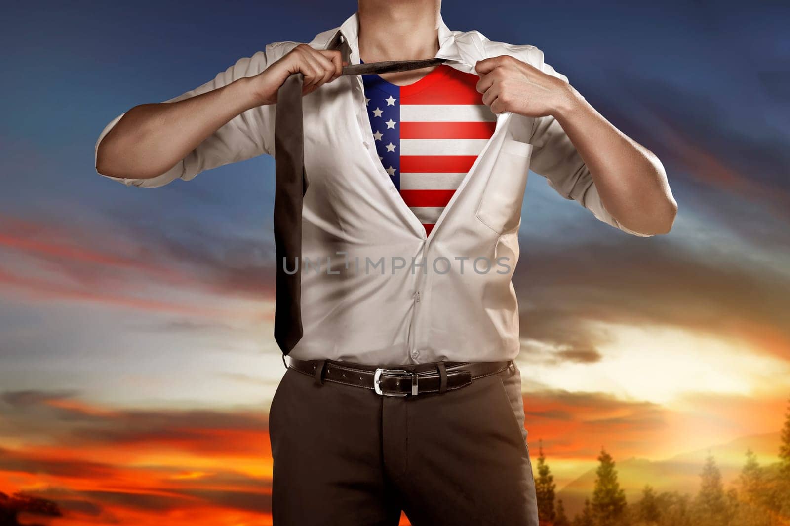 Business man tears open his shirt with american flag in a super hero fashion getting ready to save the day. 4th of July concept