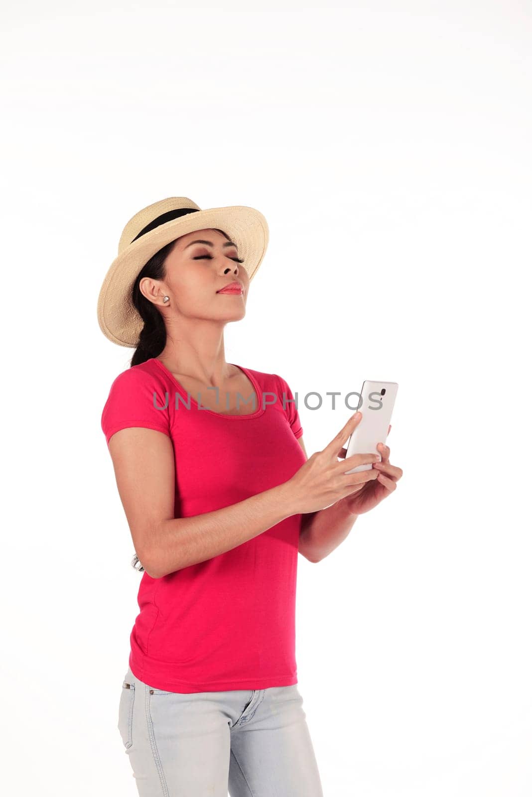 Asian tourist wearing hat holding cellphone isolated over white background