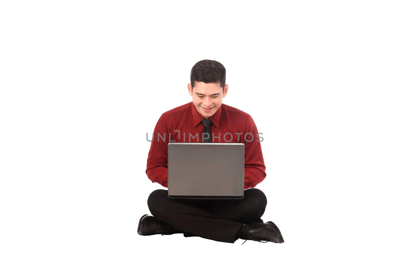 Asian business man working on a laptop and sitting on the floor isolated over white background
