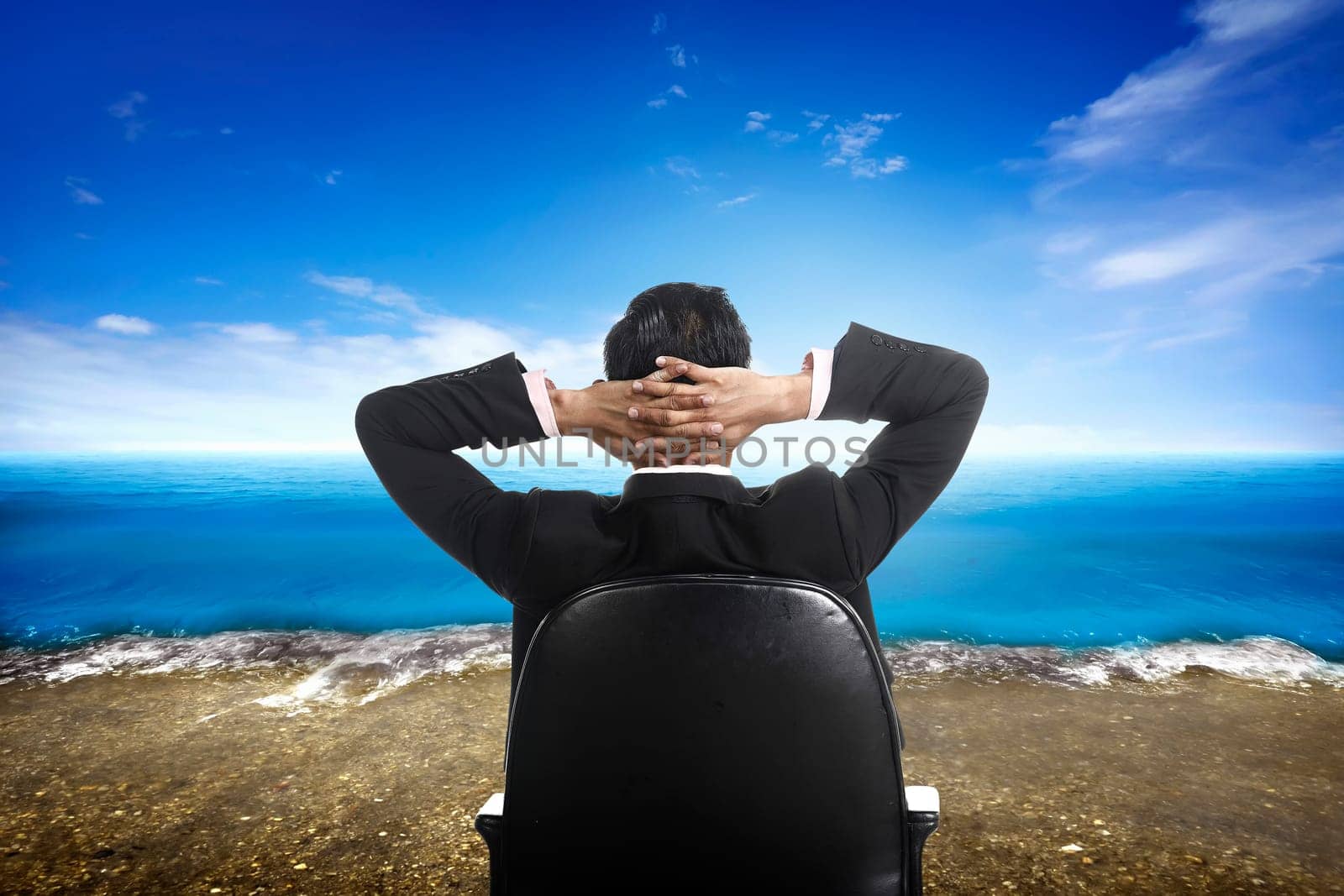 Successful business man on the beach with blue sky background