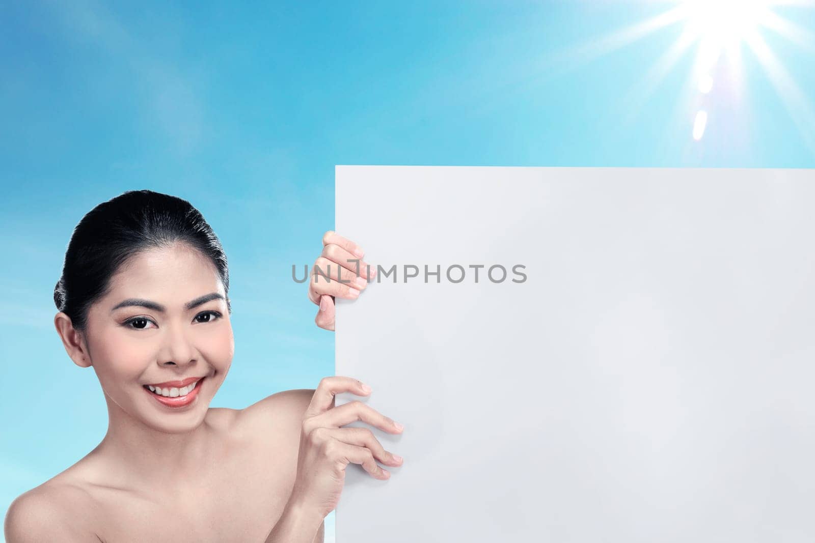 Pretty asian woman holding blank banner over blur background