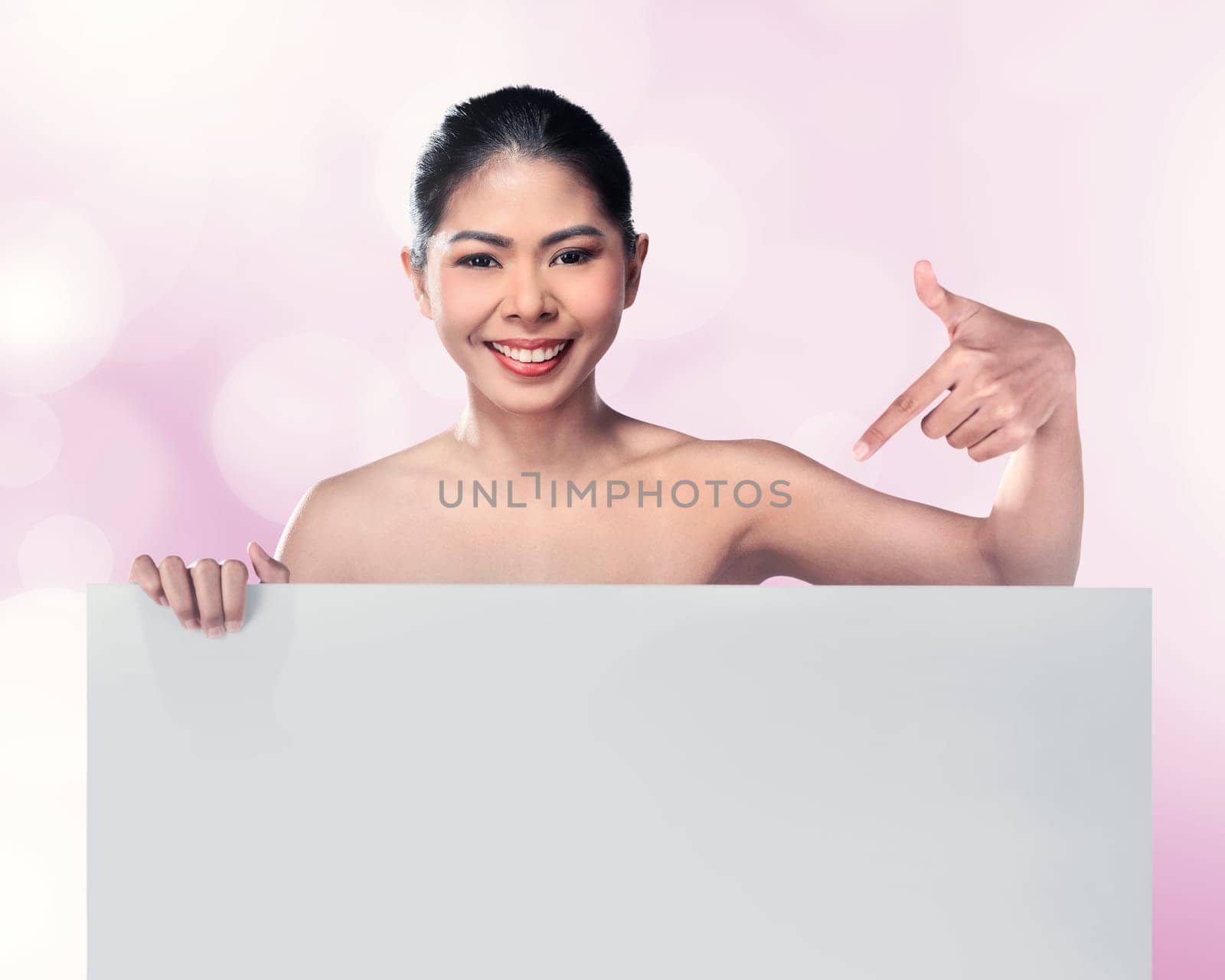 Beautiful asian woman smile pointing blank board over blur background