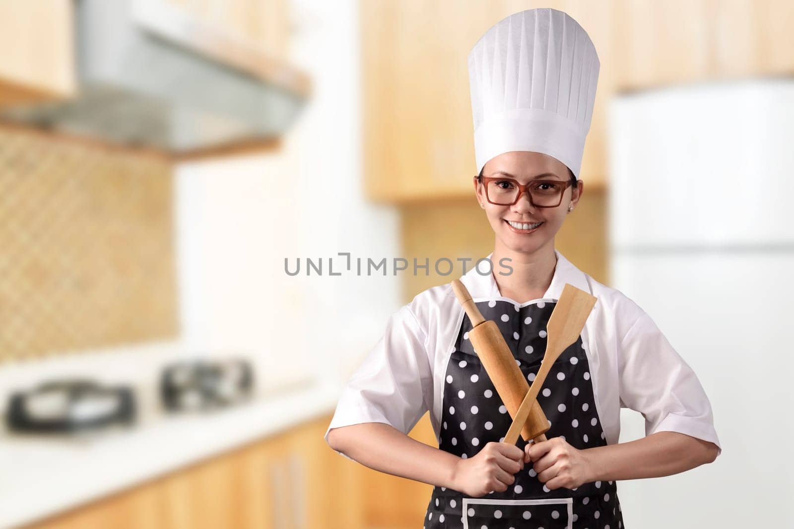 Portrait of young woman chef over kitchen background