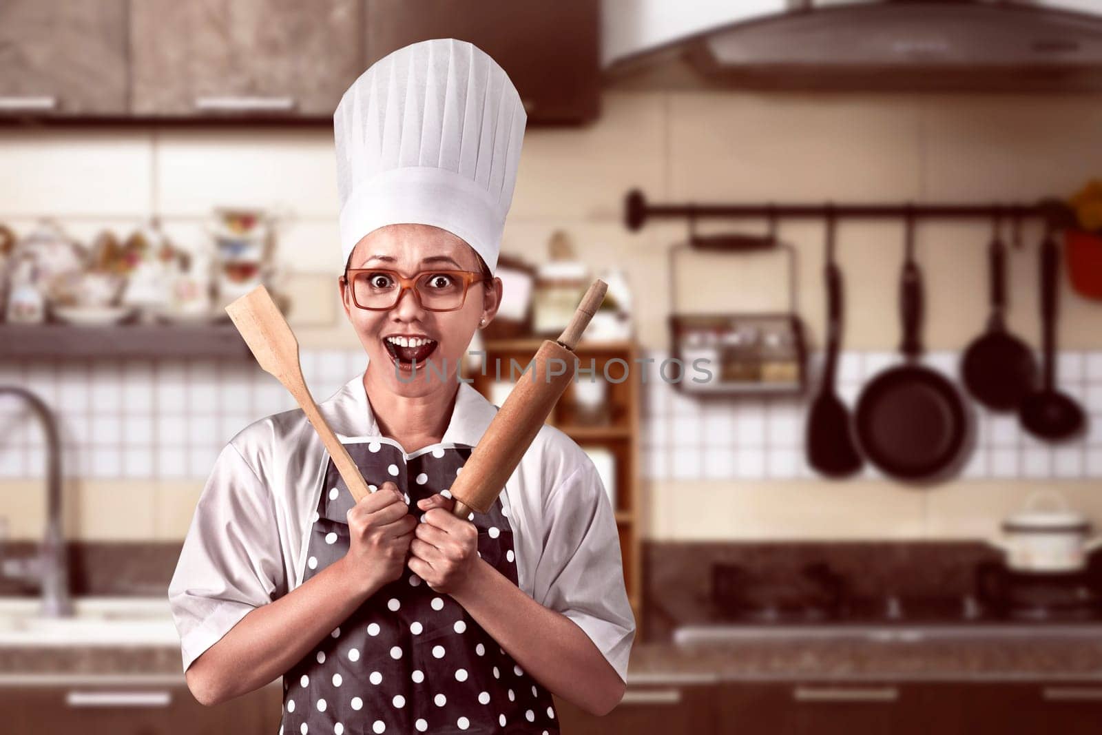 Portrait of young woman chef over kitchen background