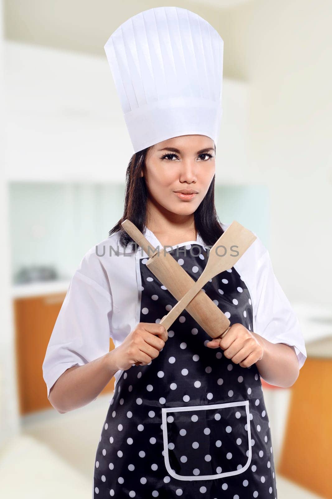 Portrait of young woman chef over kitchen background