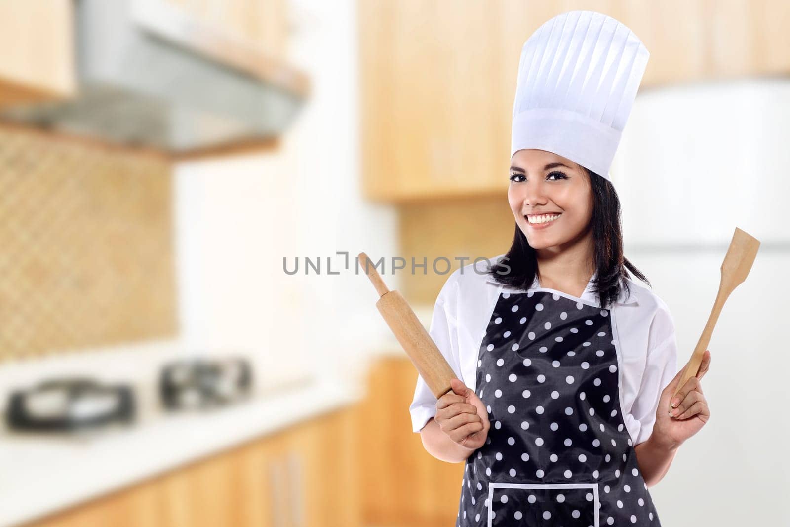 Portrait of young woman chef over kitchen background