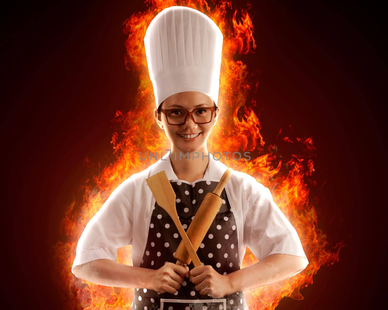 Portrait of young woman chef with fire around her
