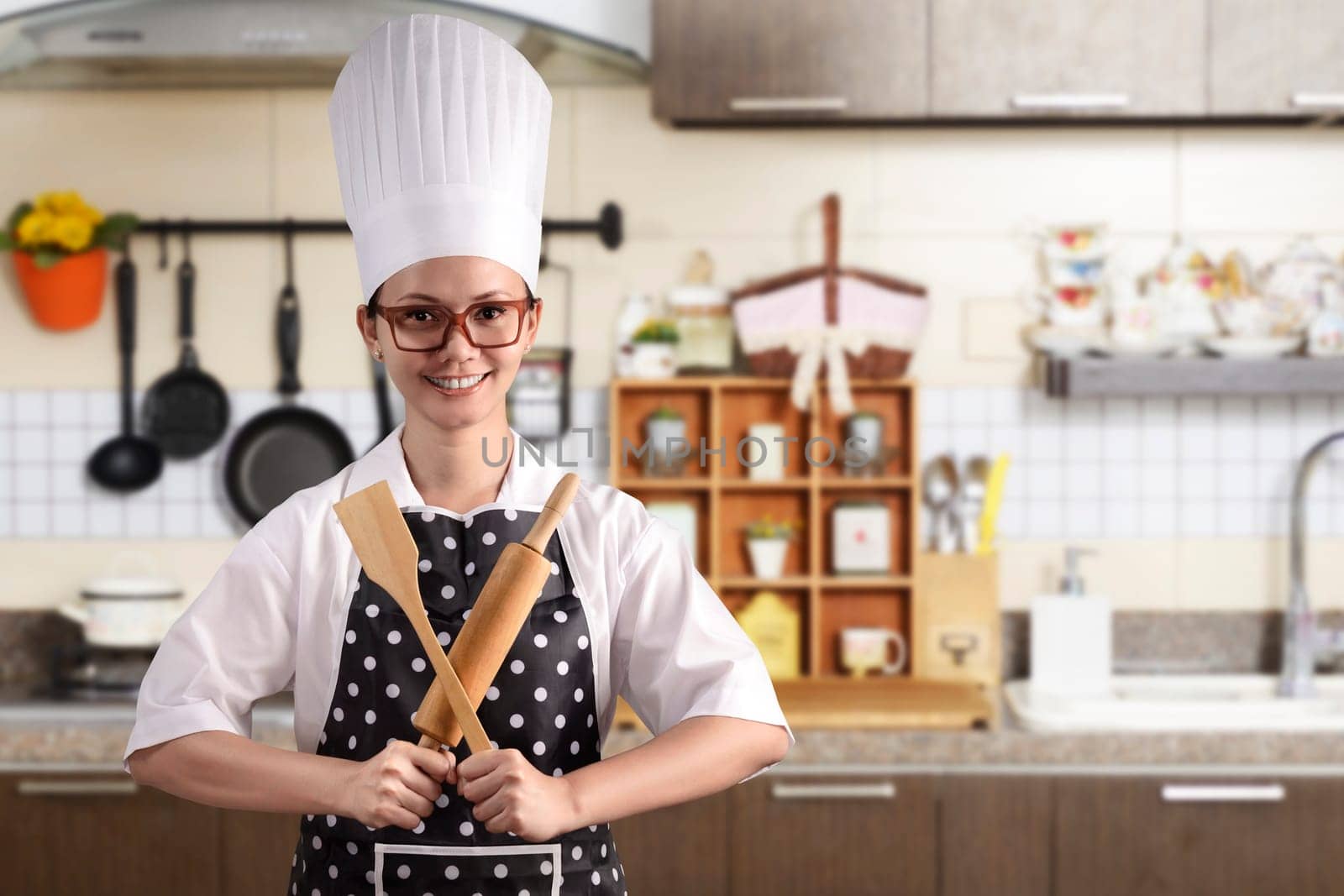 Portrait of young woman chef over kitchen background