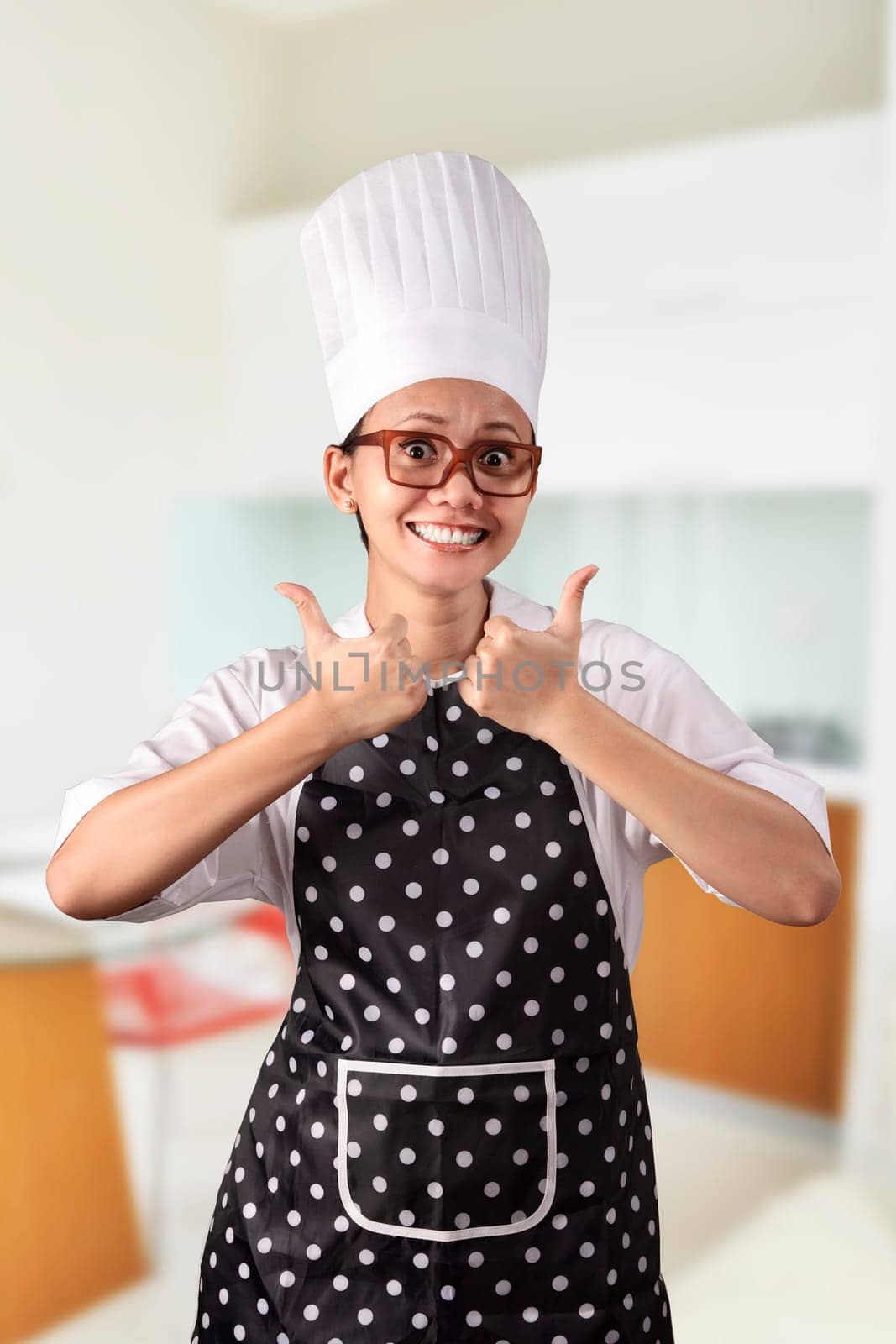 Portrait of young woman chef over kitchen background