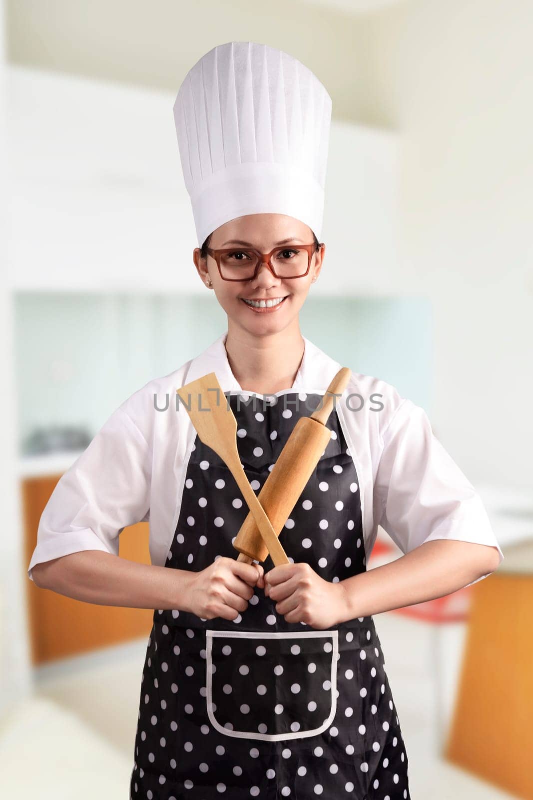 Portrait of young woman chef over kitchen background