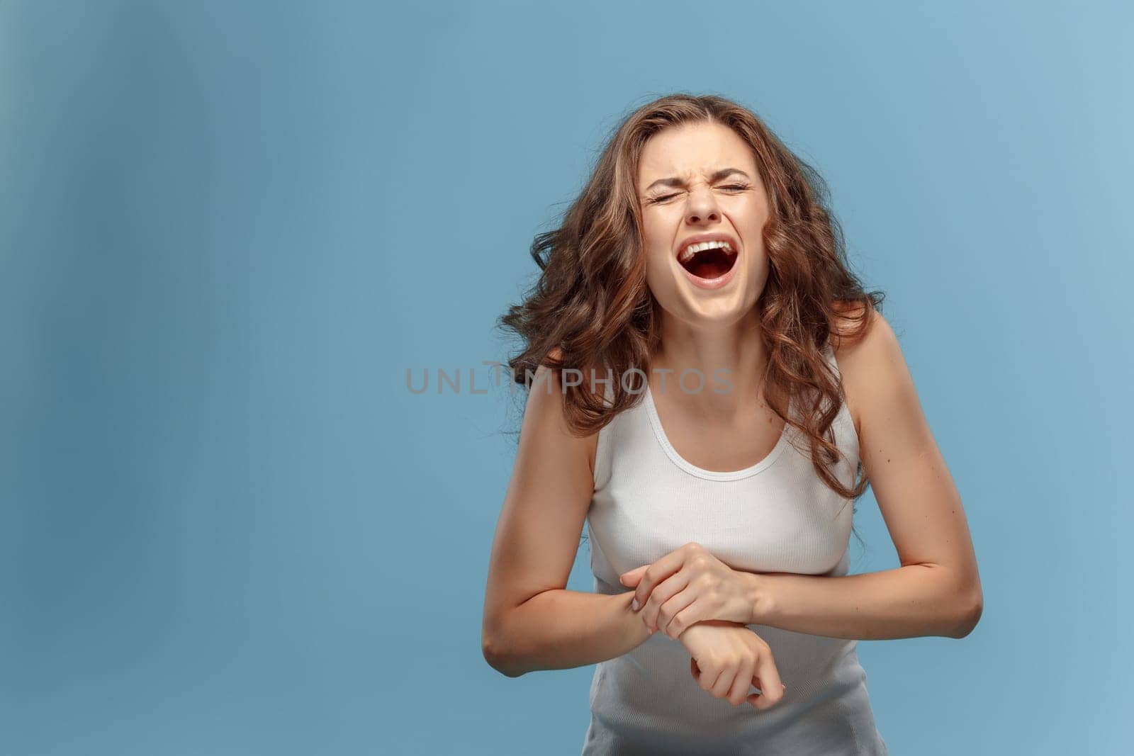 The unhappy woman suffering from pain in hand at studio
