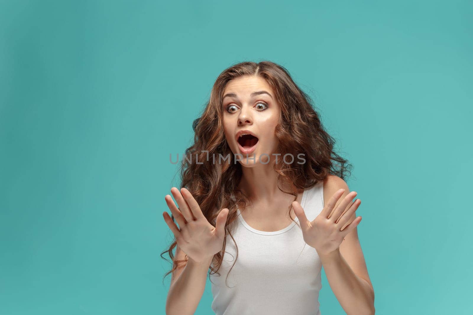 The portrait of alarmed young woman with shocked facial expression